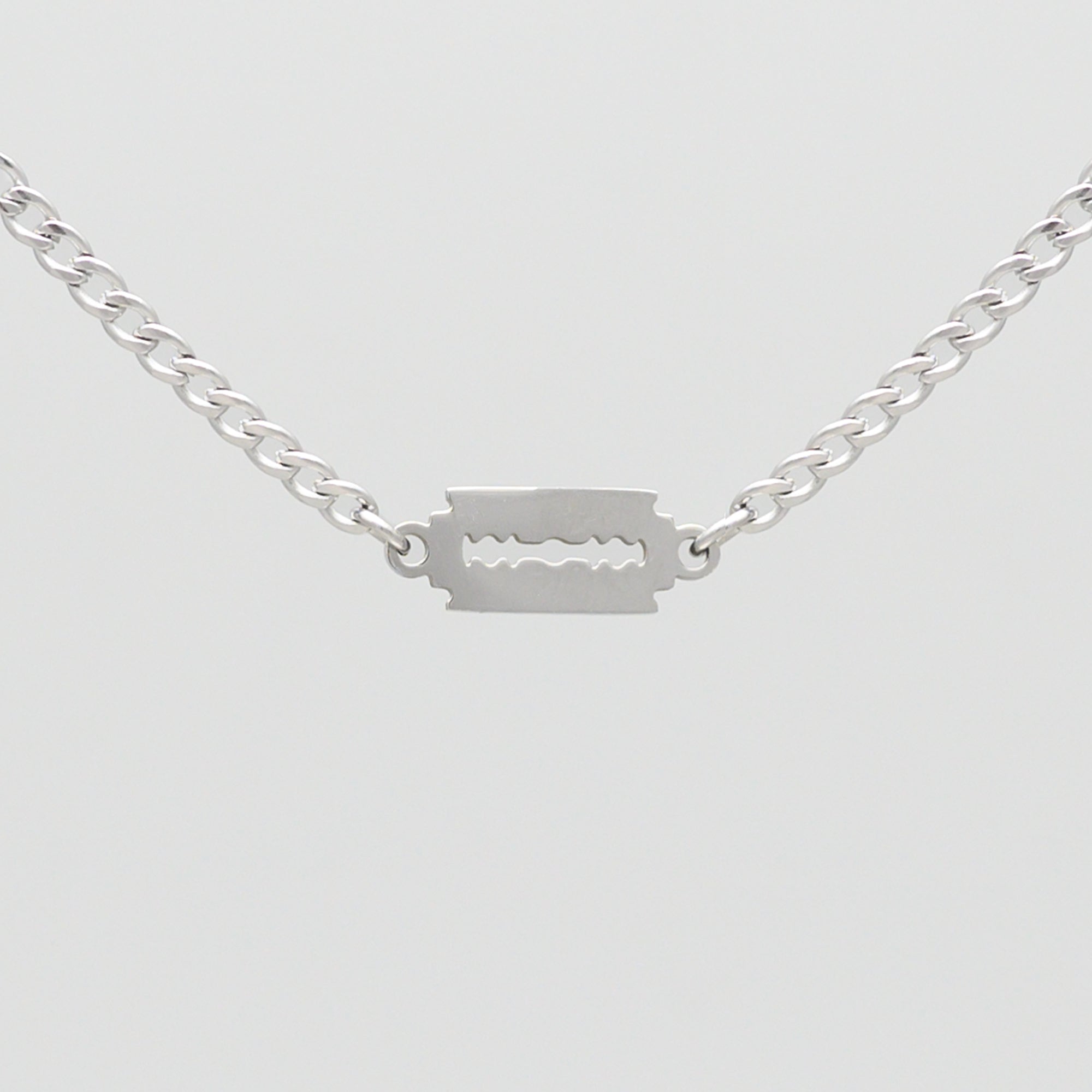 Silver dainty razor blade pendant on a cuban link chain choker