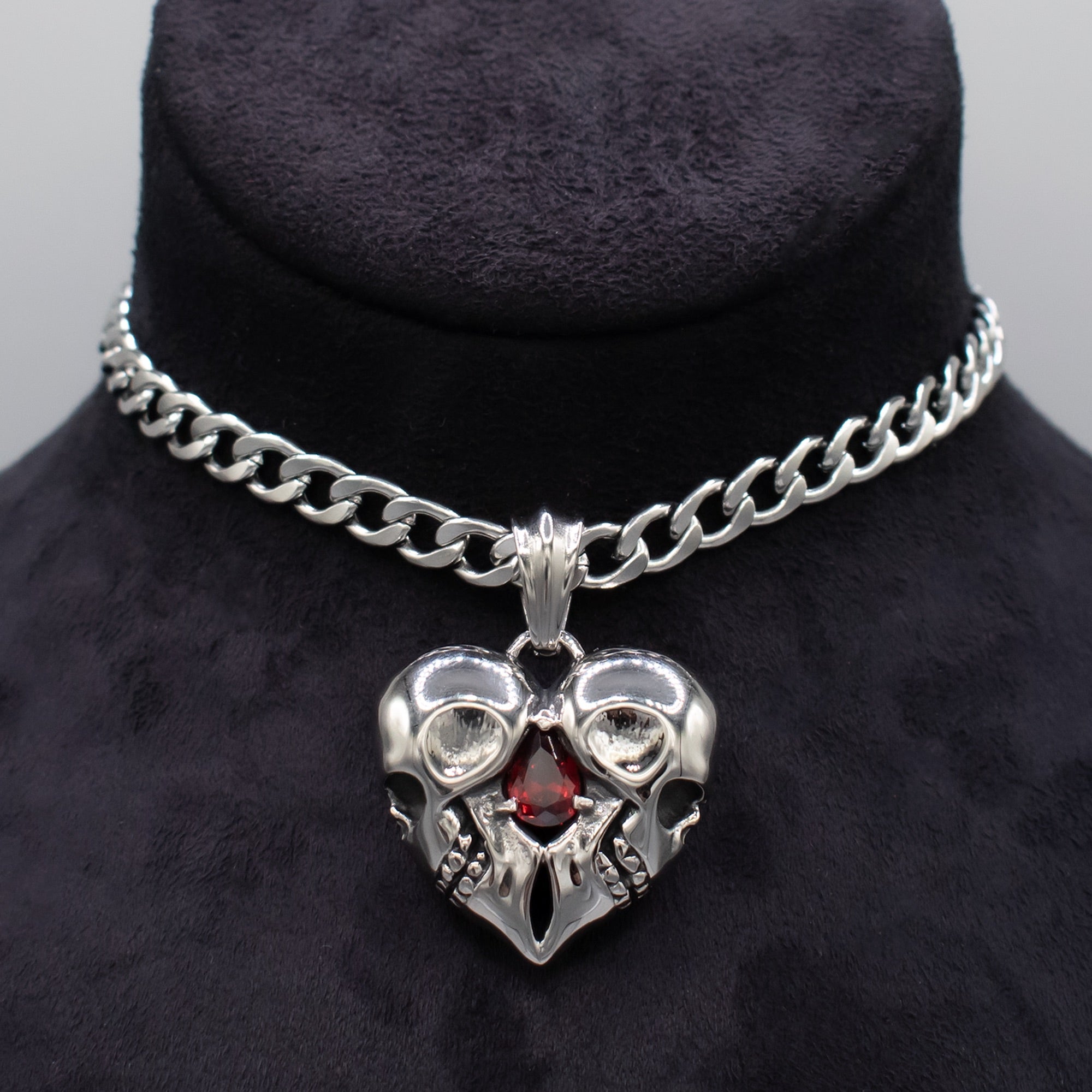 Close up of Double skull heart pendant on chunky cuban choker chain
