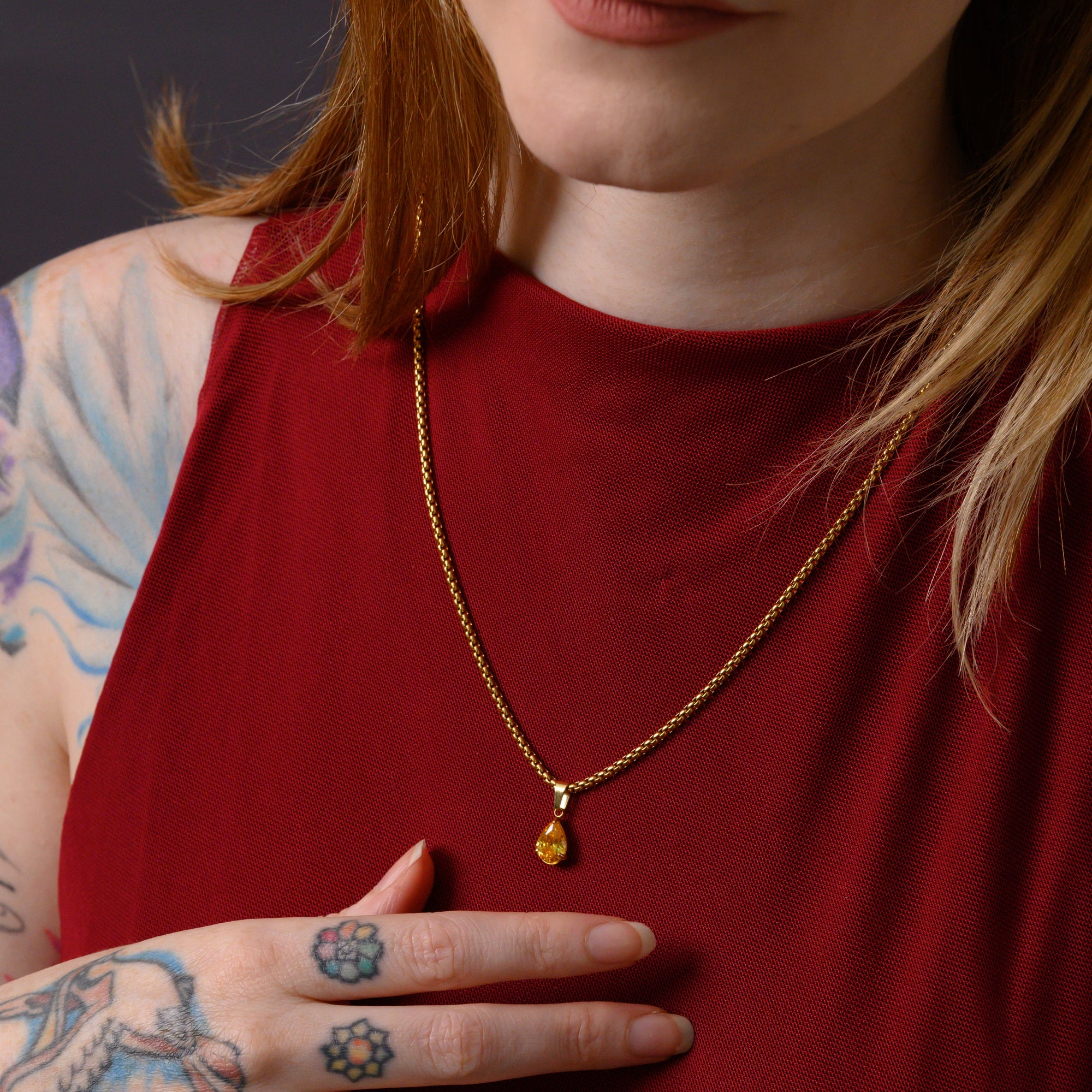 Model wears a citrine November birthstone pear cut pendant necklace in gold