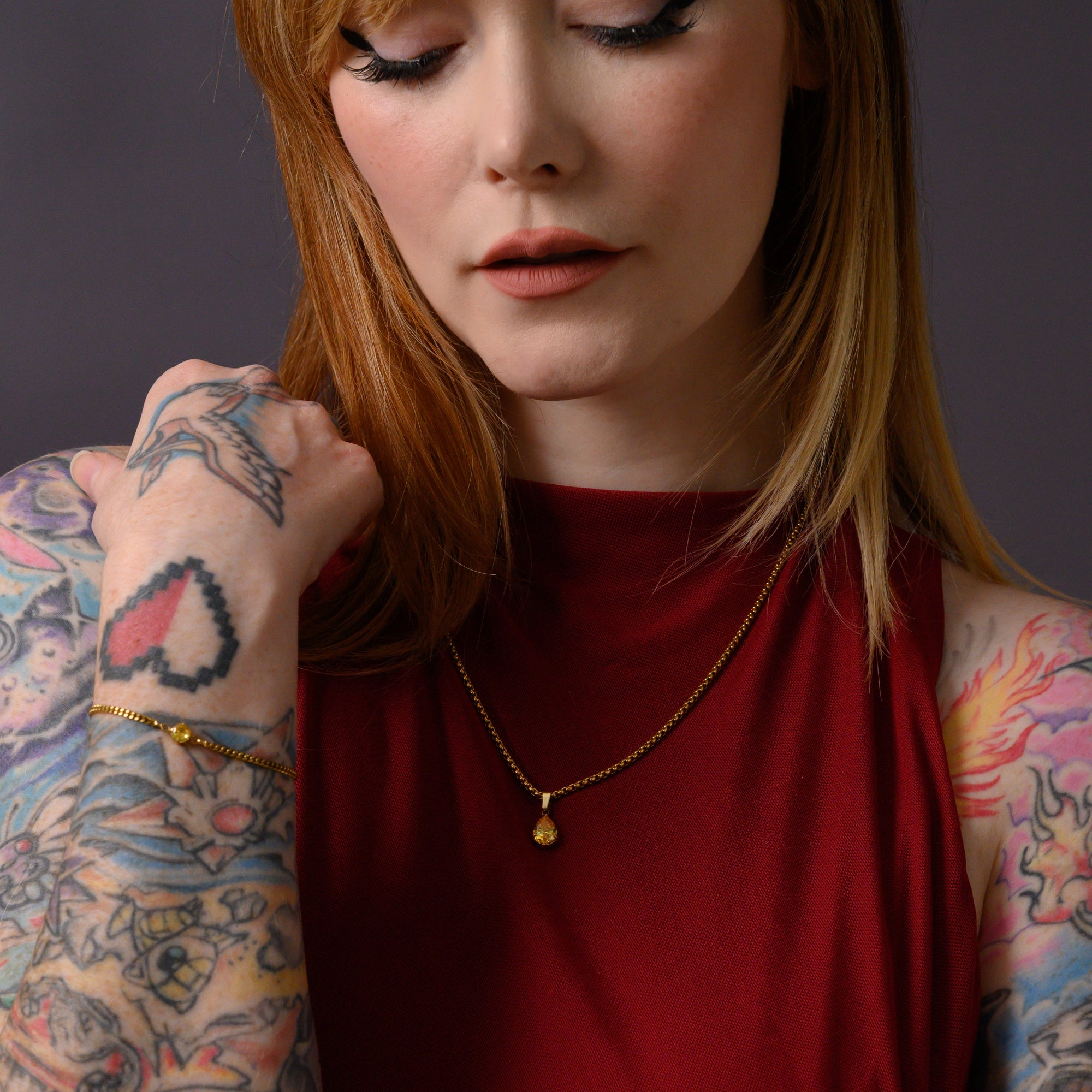 Model wears a citrine November birthstone pear cut pendant necklace in gold