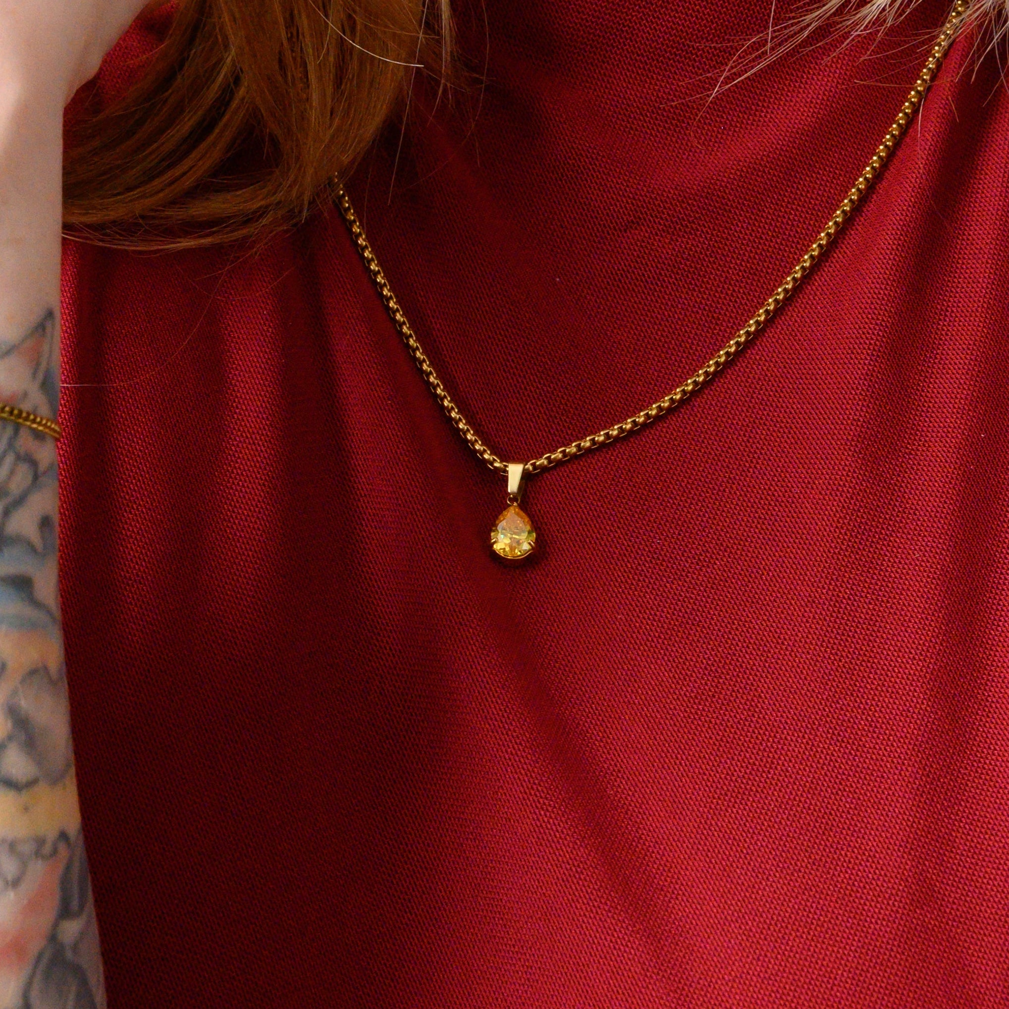 Model wears a citrine November birthstone pear cut pendant necklace in gold