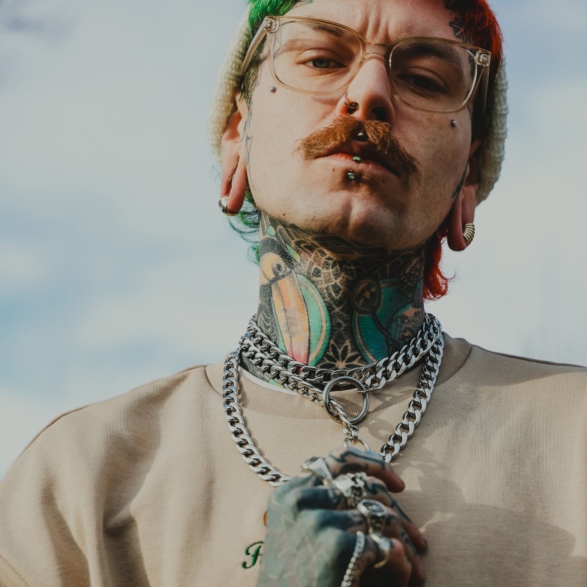 man wears chunky layered cuban link chains featuring a slip chain choker all in silver finish