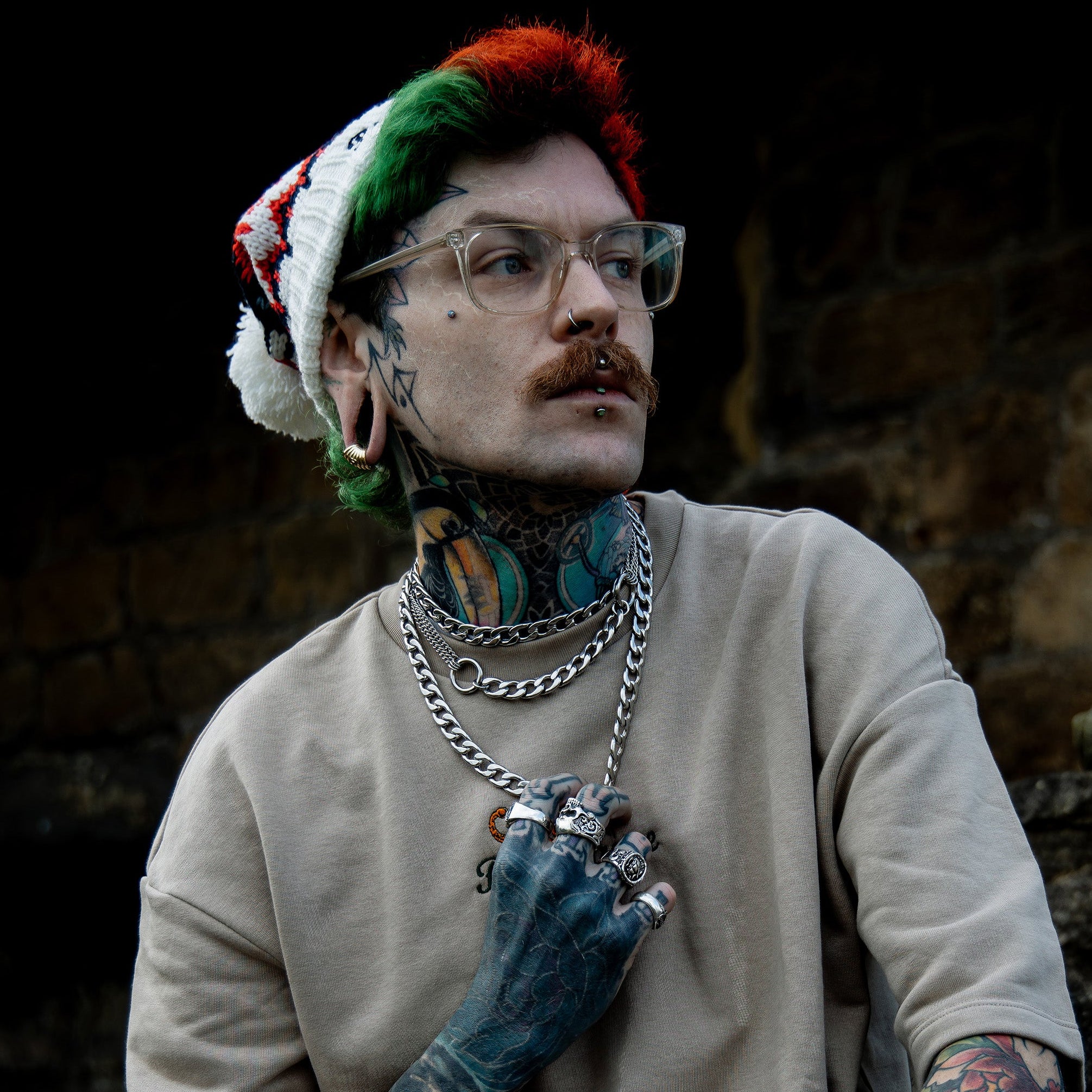 man wears double o ring choker layered with chunky silver cuban chains