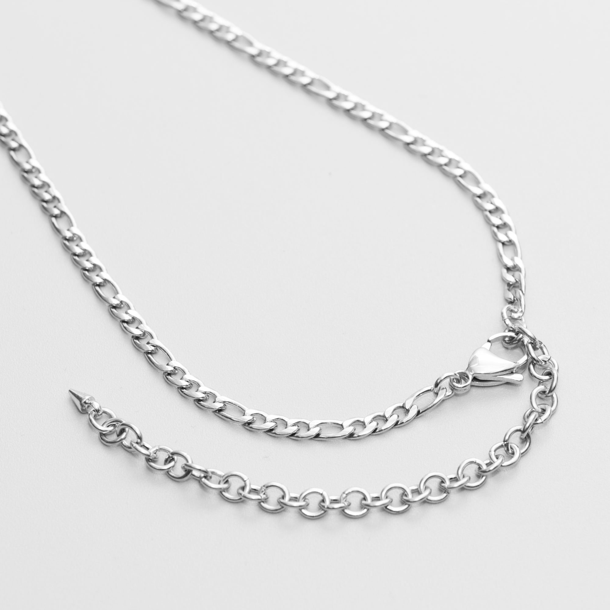 A silver padlock pendant micro slip chain necklace with a Figaro link chain and a lobster clasp closure, presented on a black gift box