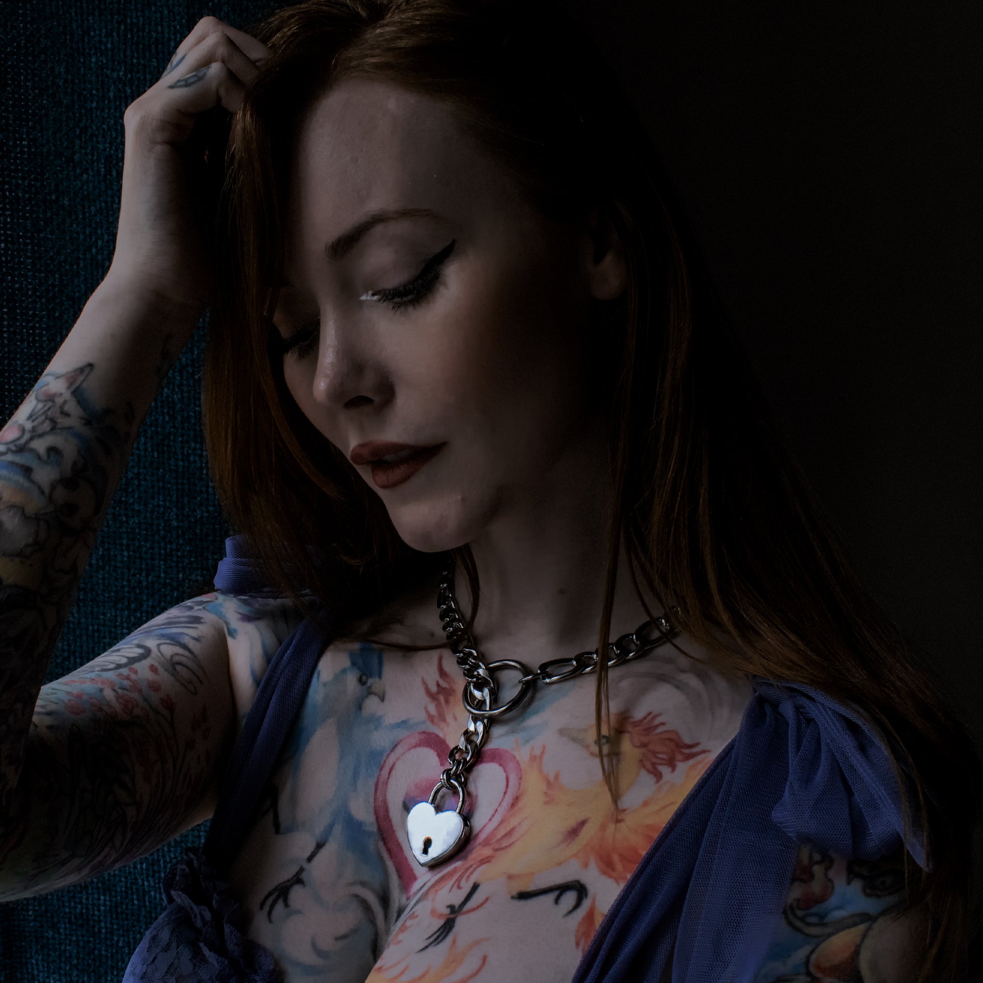 Model wears silver coloured figaro style slip chain choker with heart shaped padlock