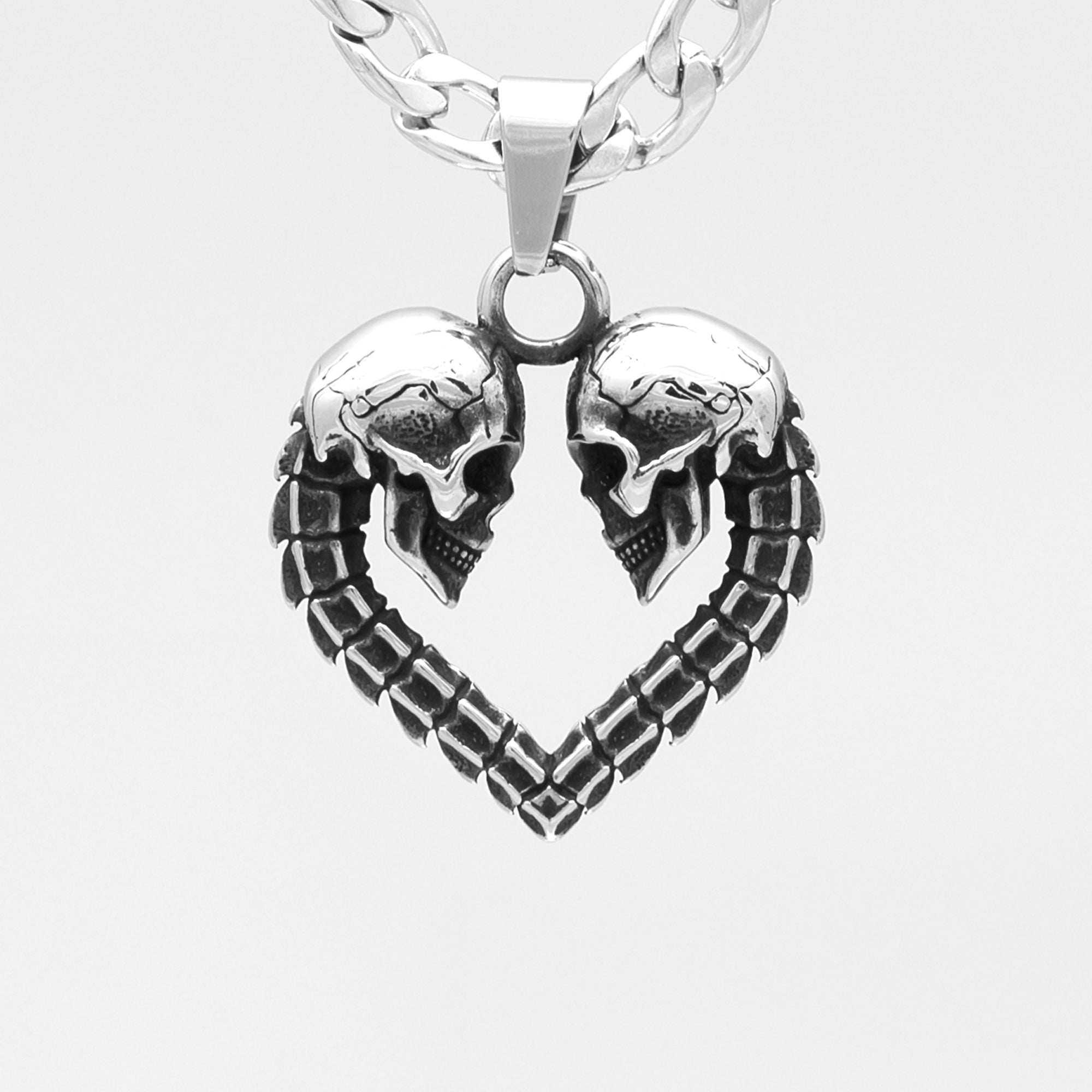 Silver heart shaped double skull pendant on cuban chain necklace