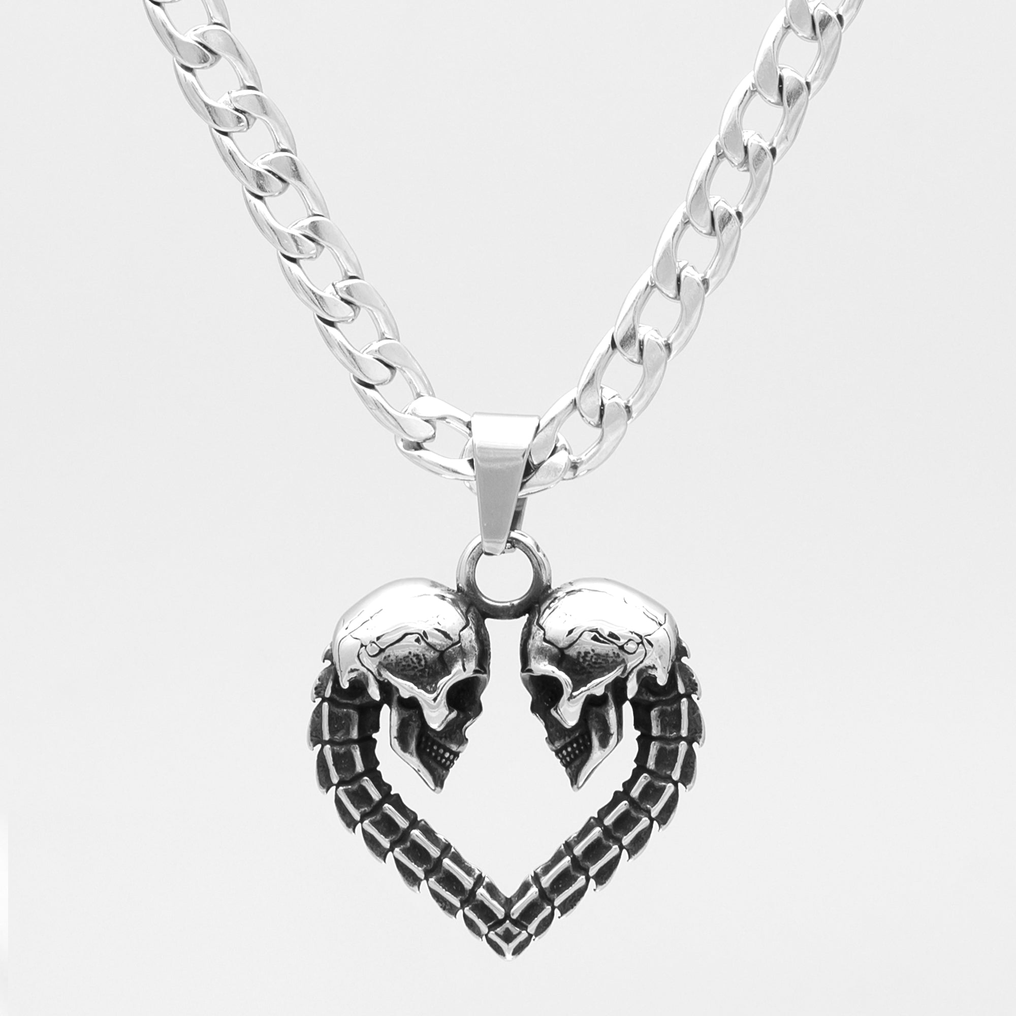 Silver heart shaped double skull pendant on cuban chain necklace