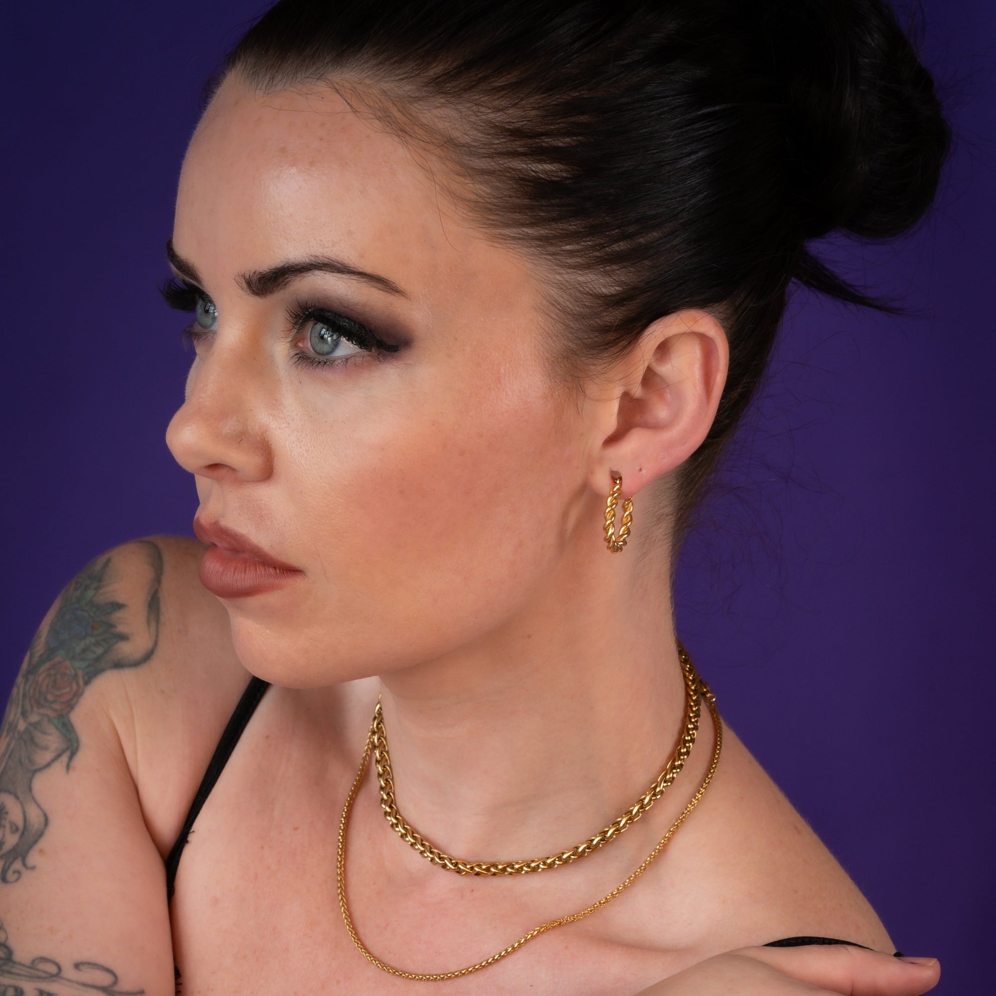 Woman wearing large twisted gold hoop earrings