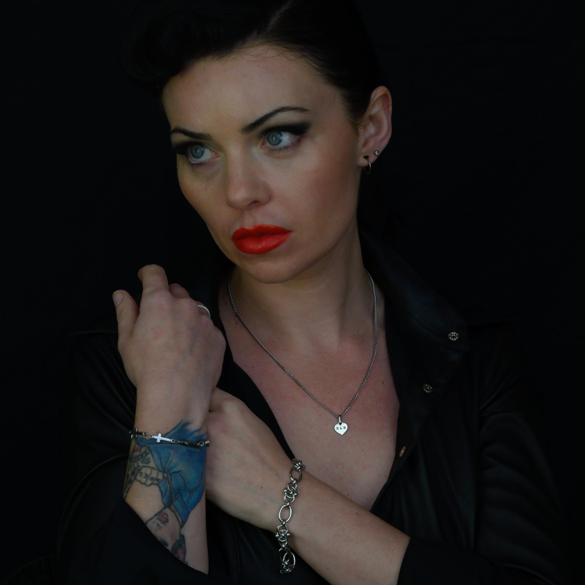 Woman with red lipstick and tattoos on a black background