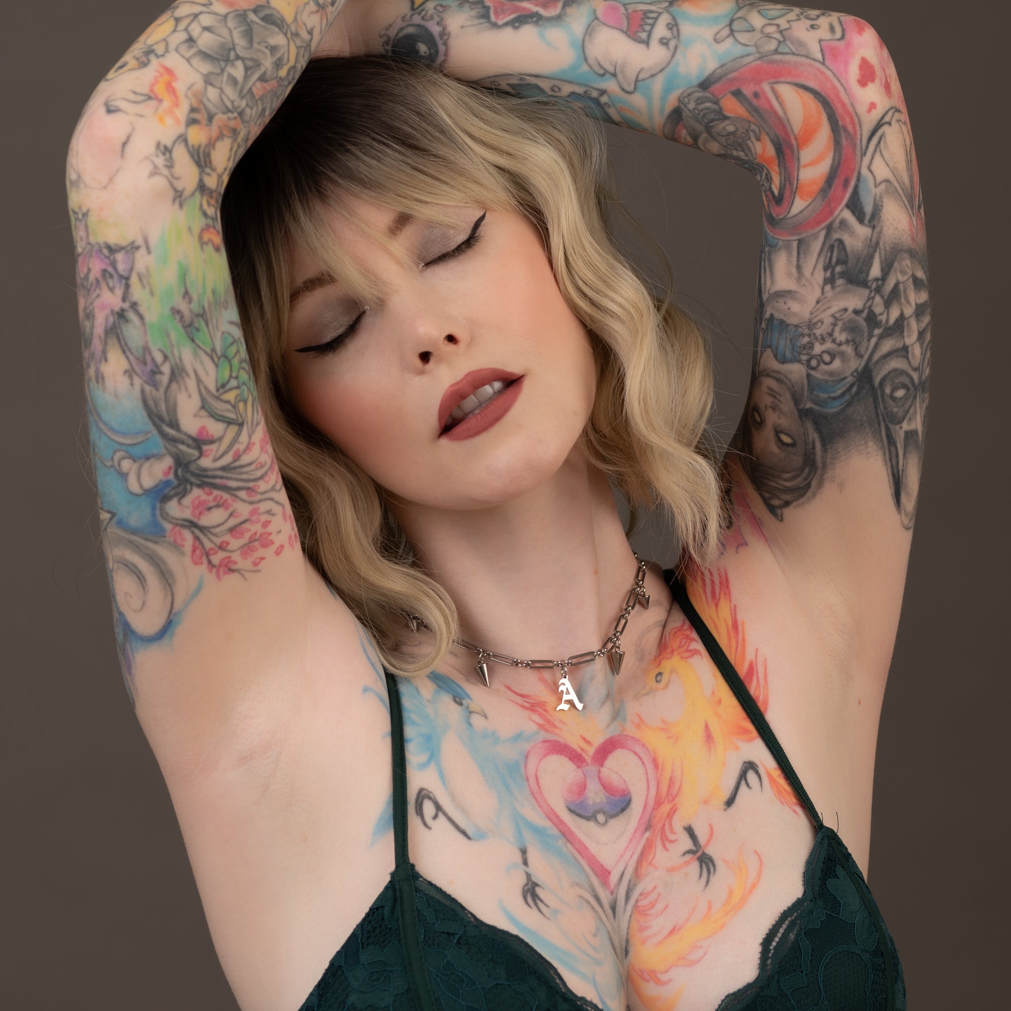 Blonde tattooed model wears old English Gothic initial spiked choker necklace
