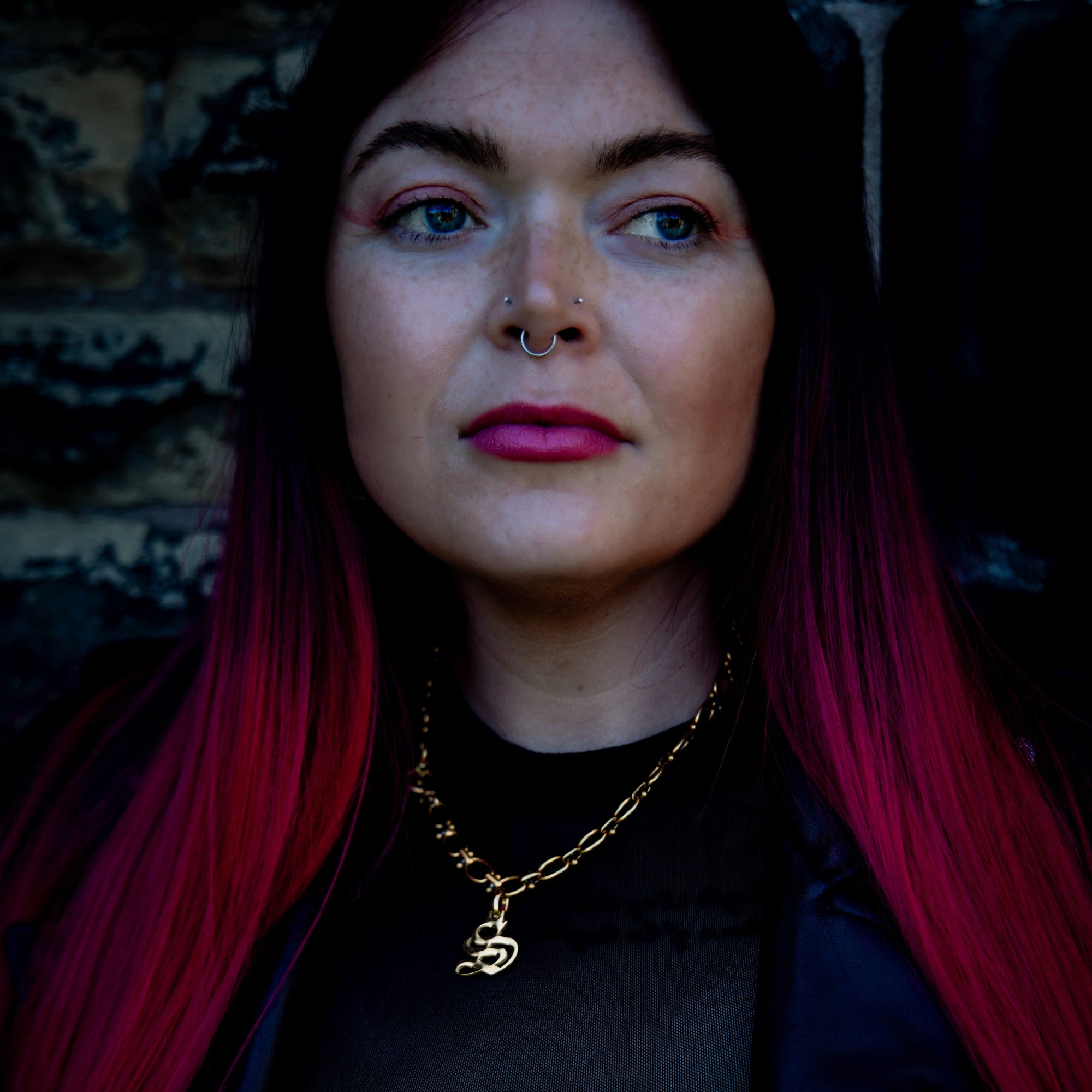 woman wears chunky oval link initial necklace in gold