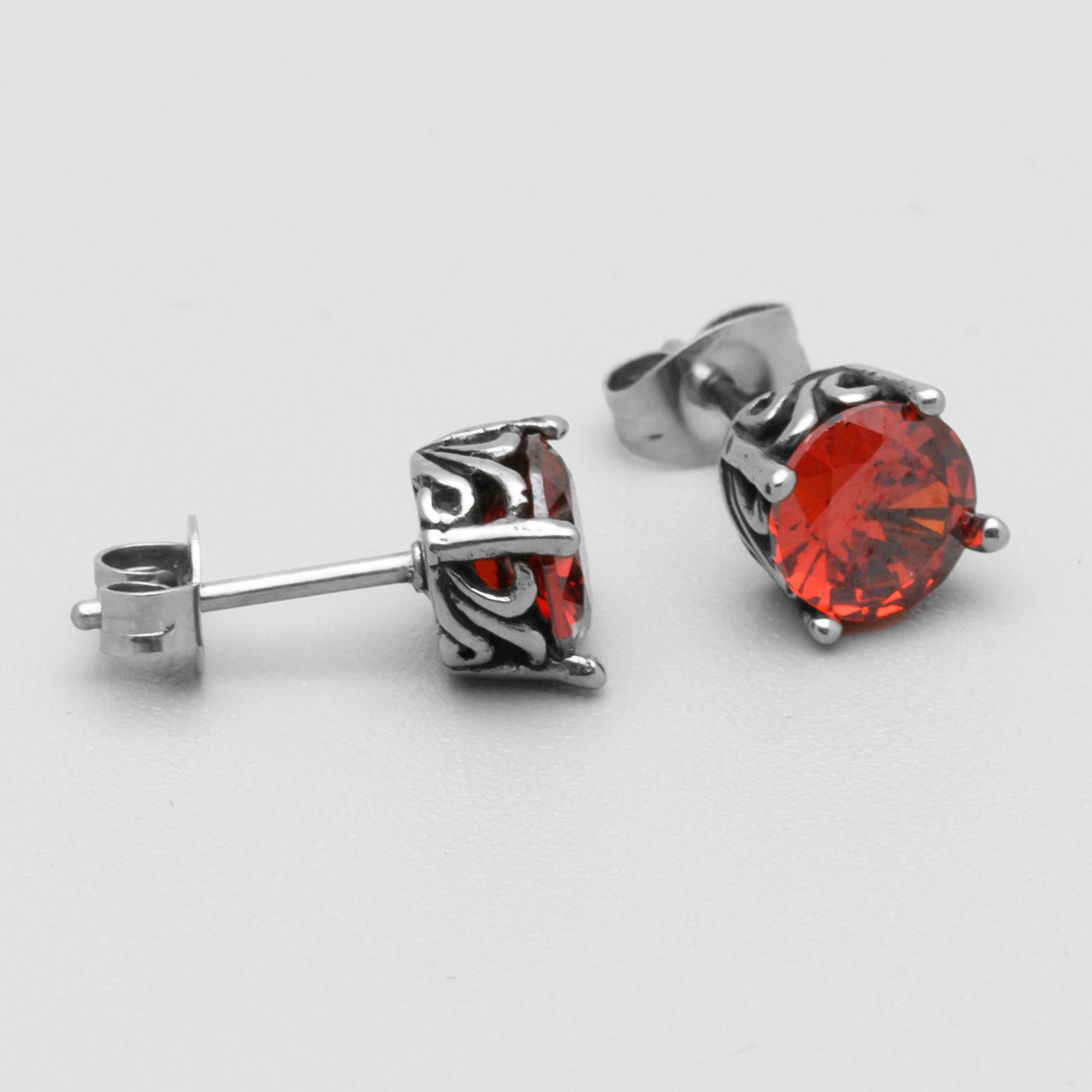 Close up of Ruby red stone gothic stud earrings in silver