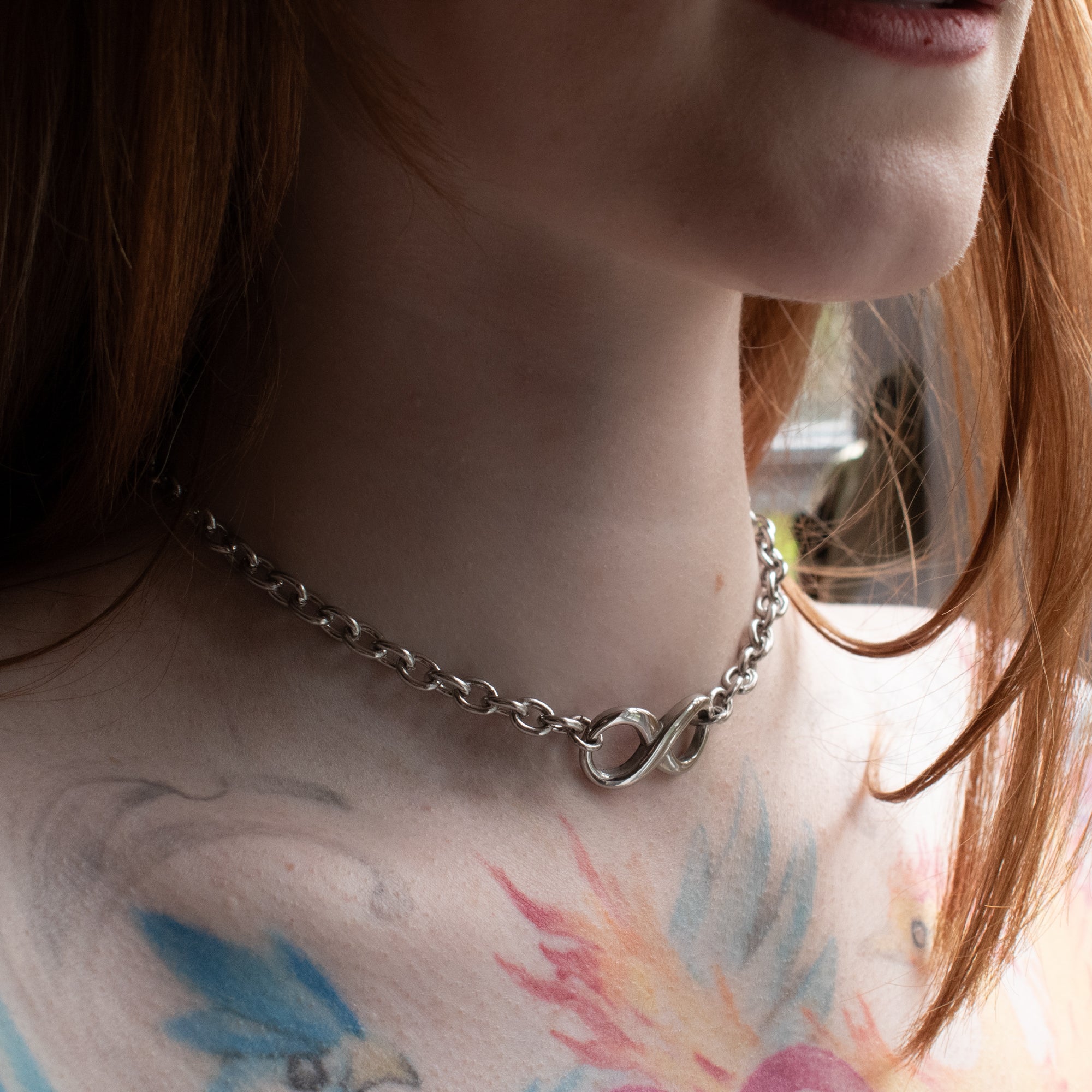 Close up pf model wearing large chunky eternity/infinity symbol silver day collar