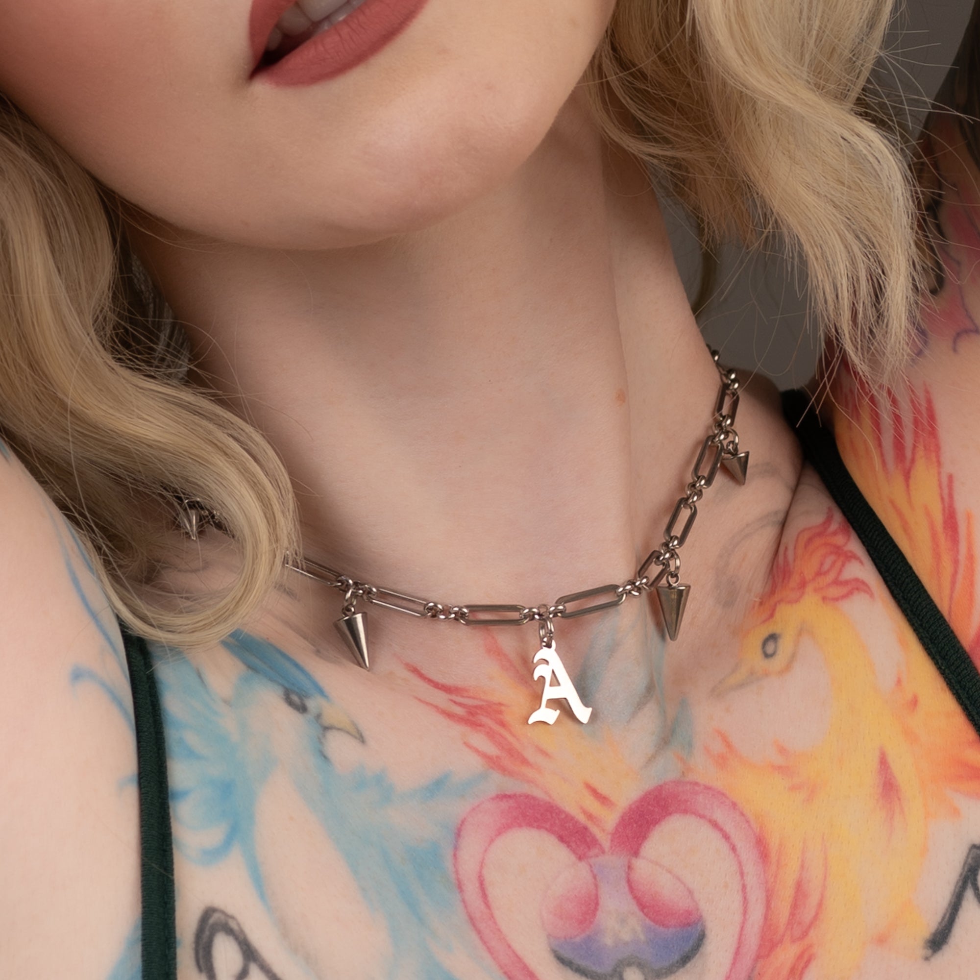 Model wears silver coloured gothic style initial choker