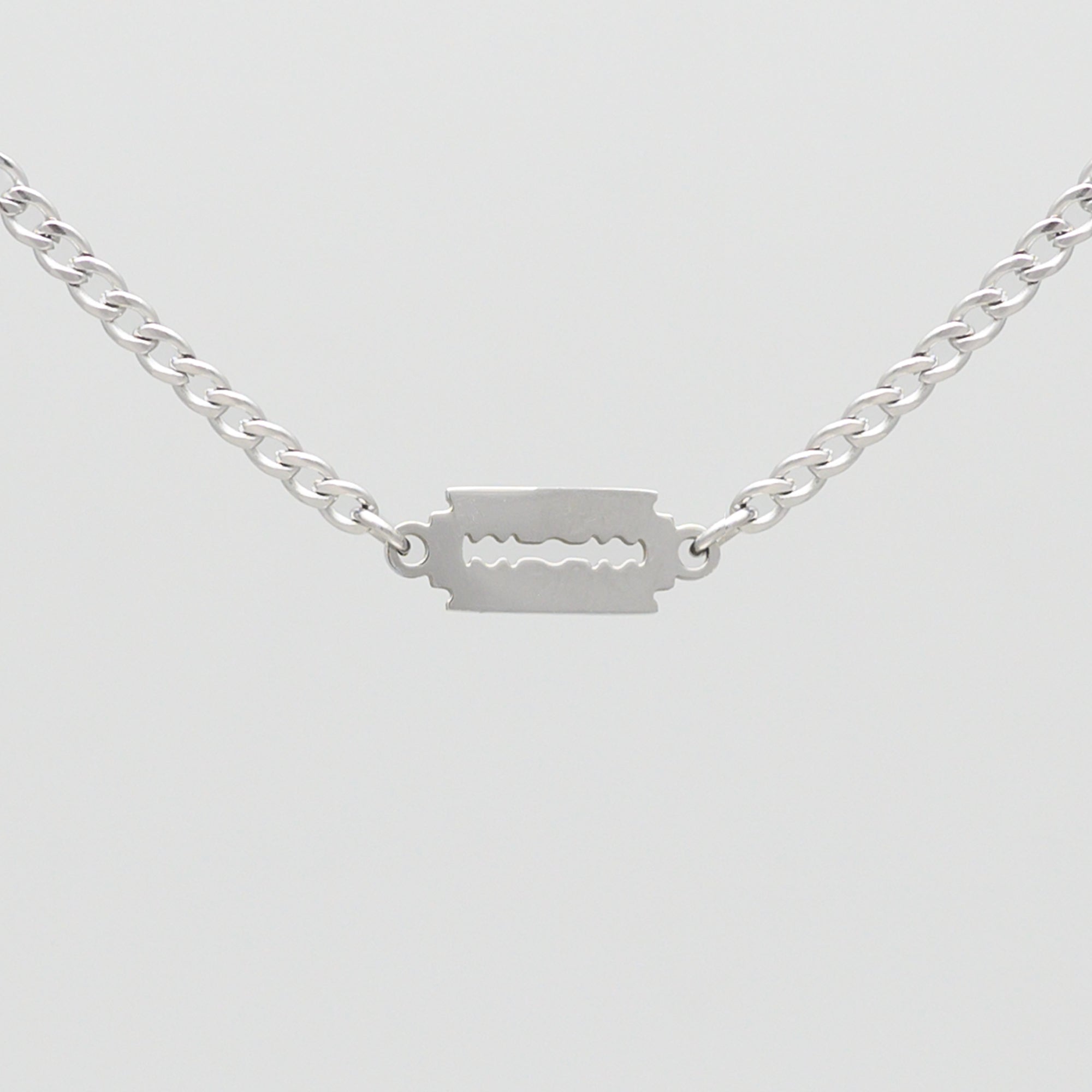 Silver dainty razor blade pendant on a cuban link chain choker