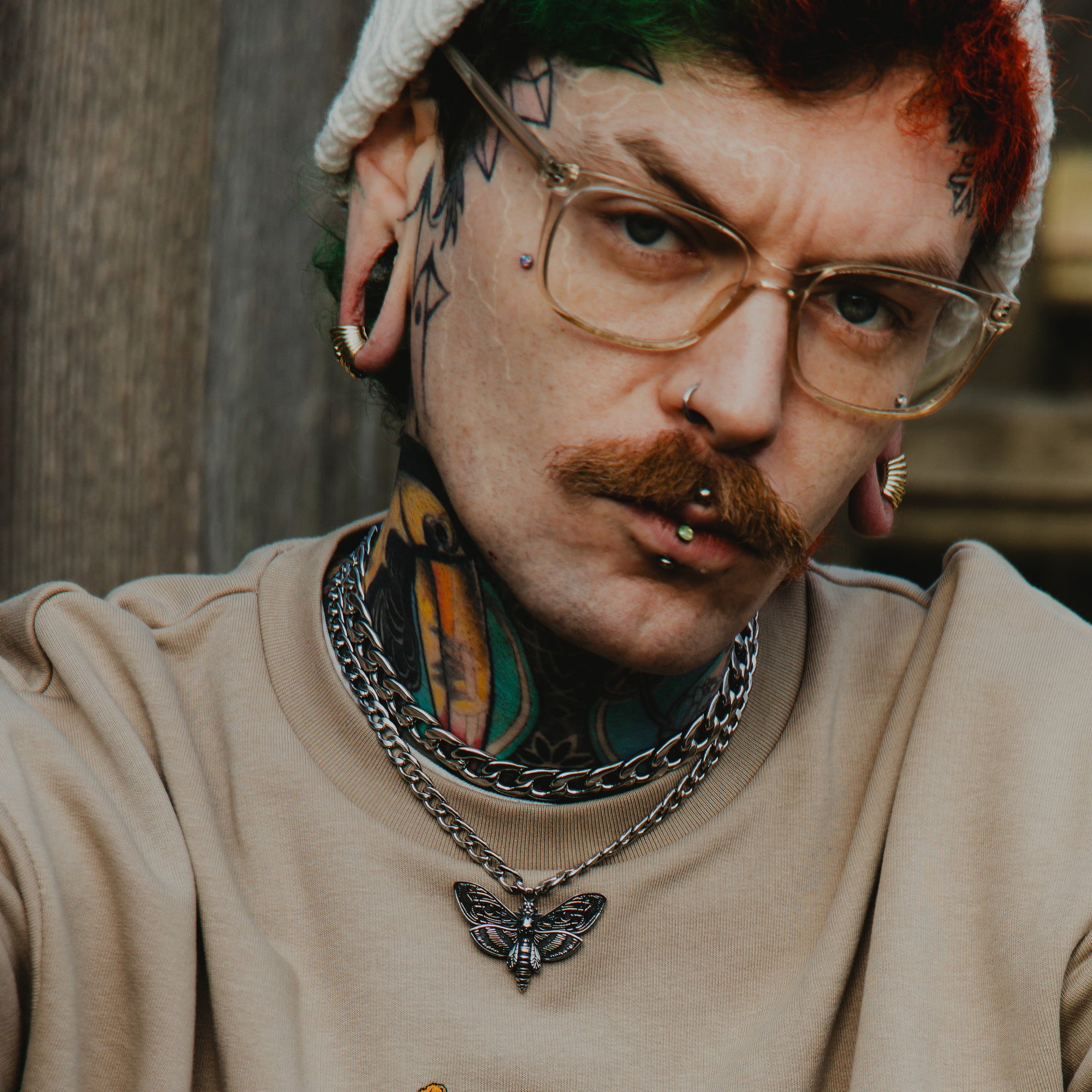 Man wearing a Death Moth Choker with layered silver chunky cuban link choker necklace 