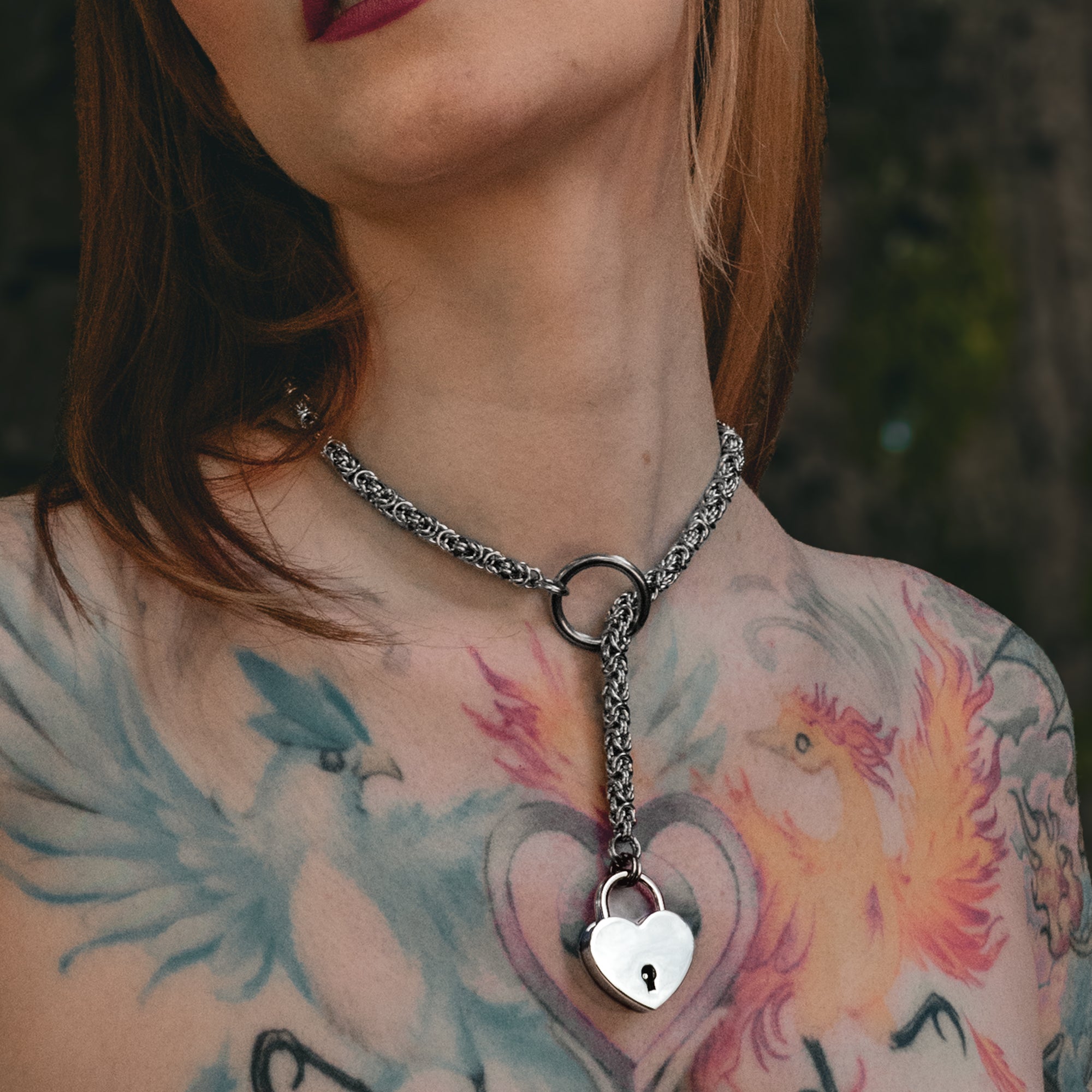 Close up of a silver coloured byzantine chainmail slip chain choker & heart padlock