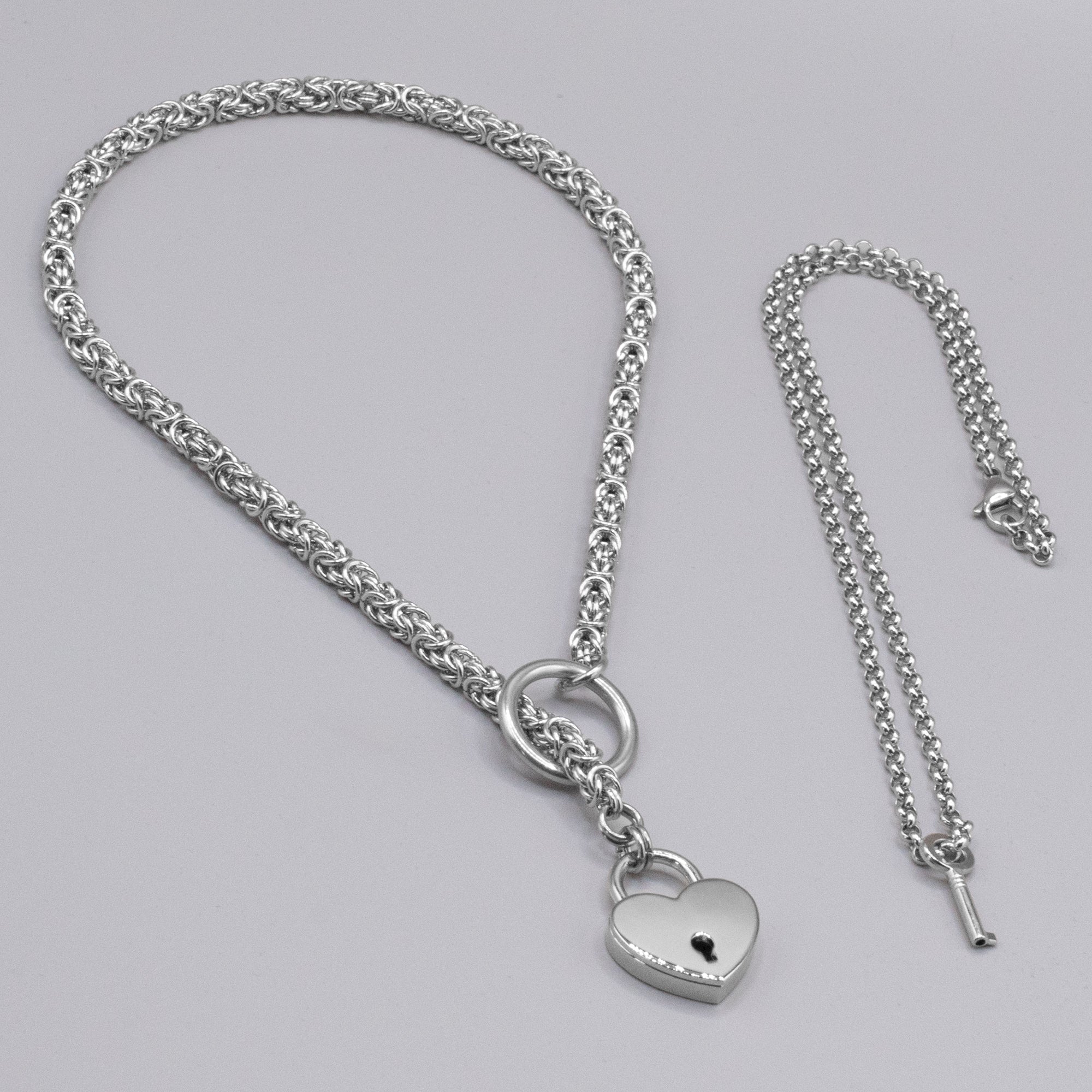 Close up of a silver coloured byzantine chainmail slip chain choker & heart padlock