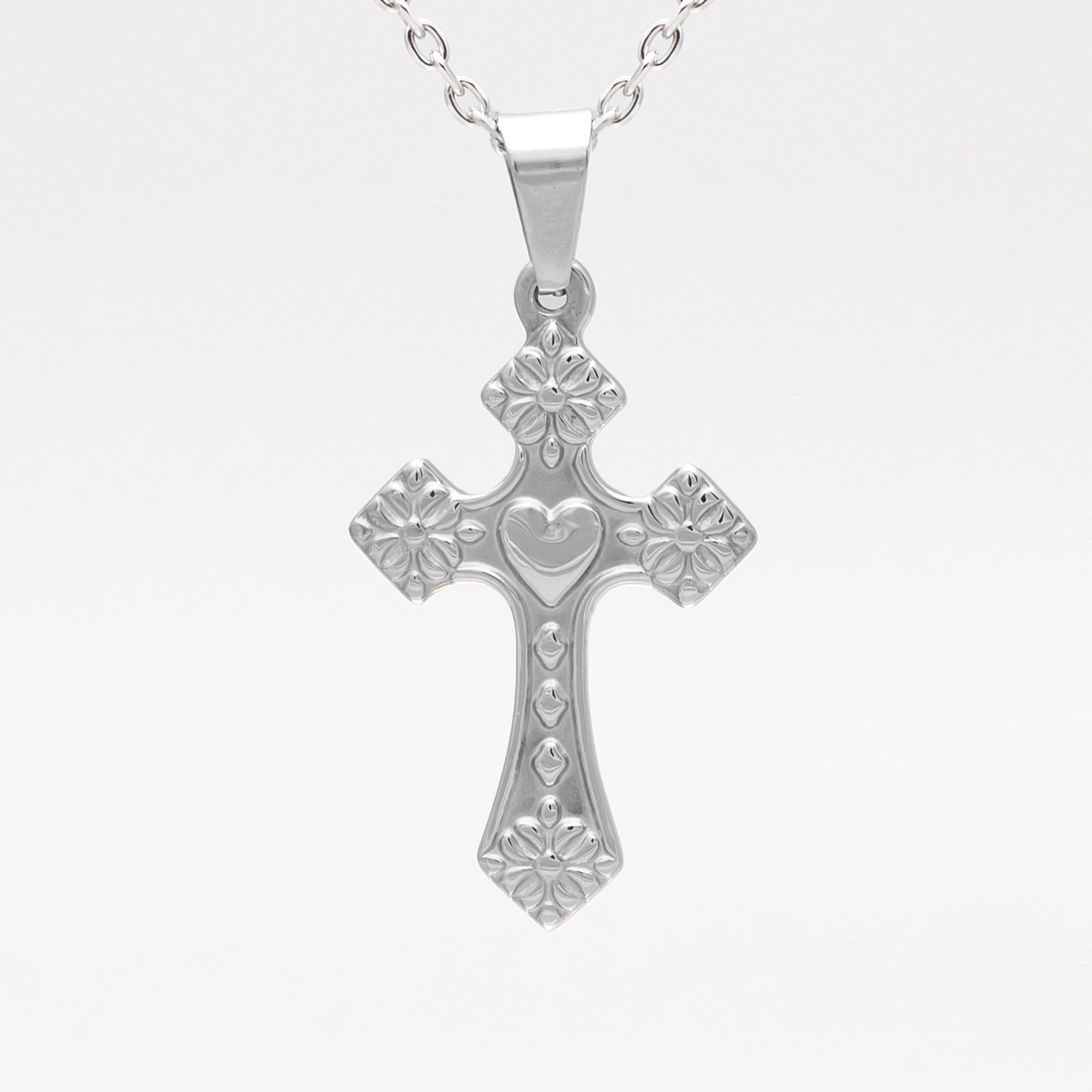 silver cross and heart pendant on a cable chain necklace