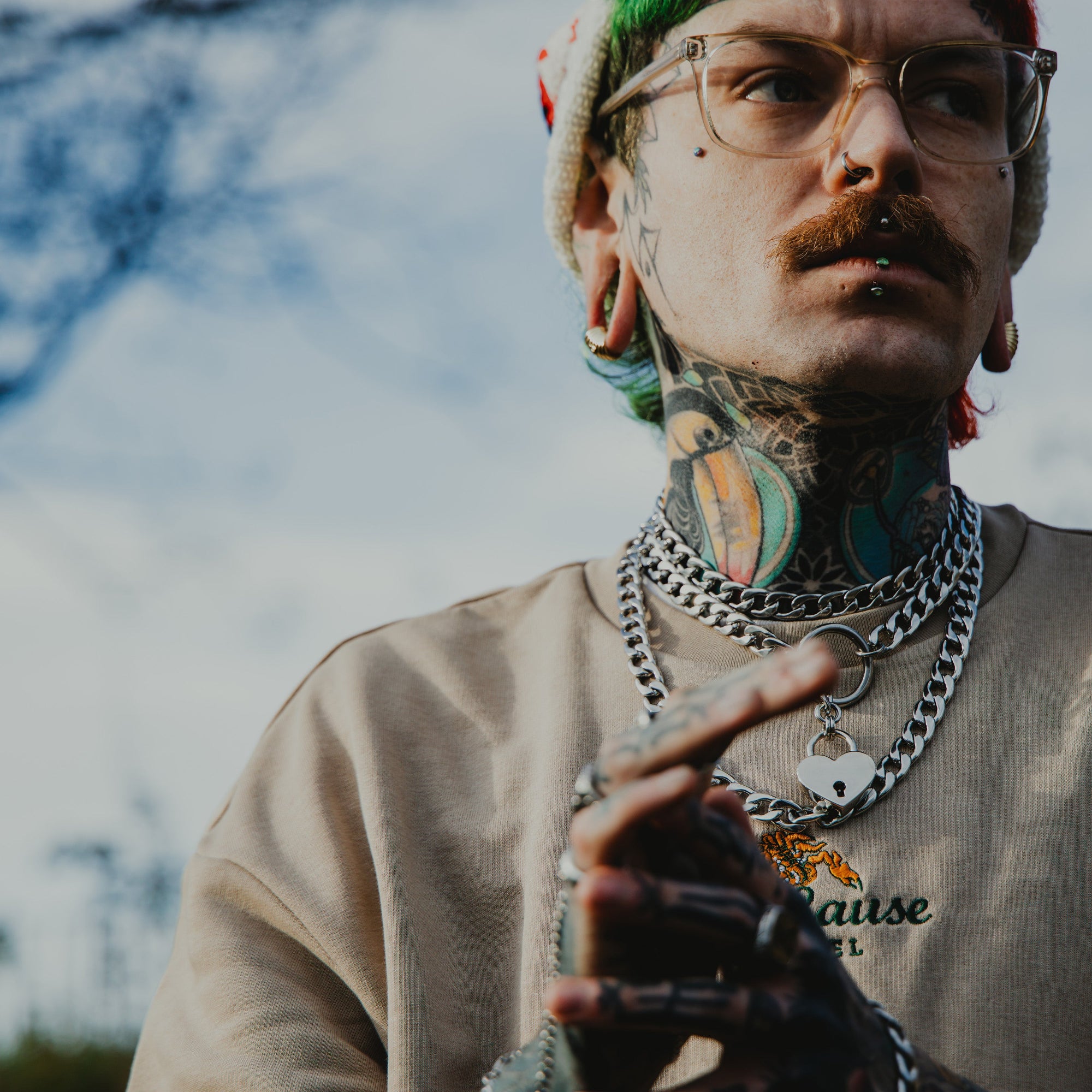 man wears chunky layered cuban link chains featuring a slip chain choker all in silver finish 