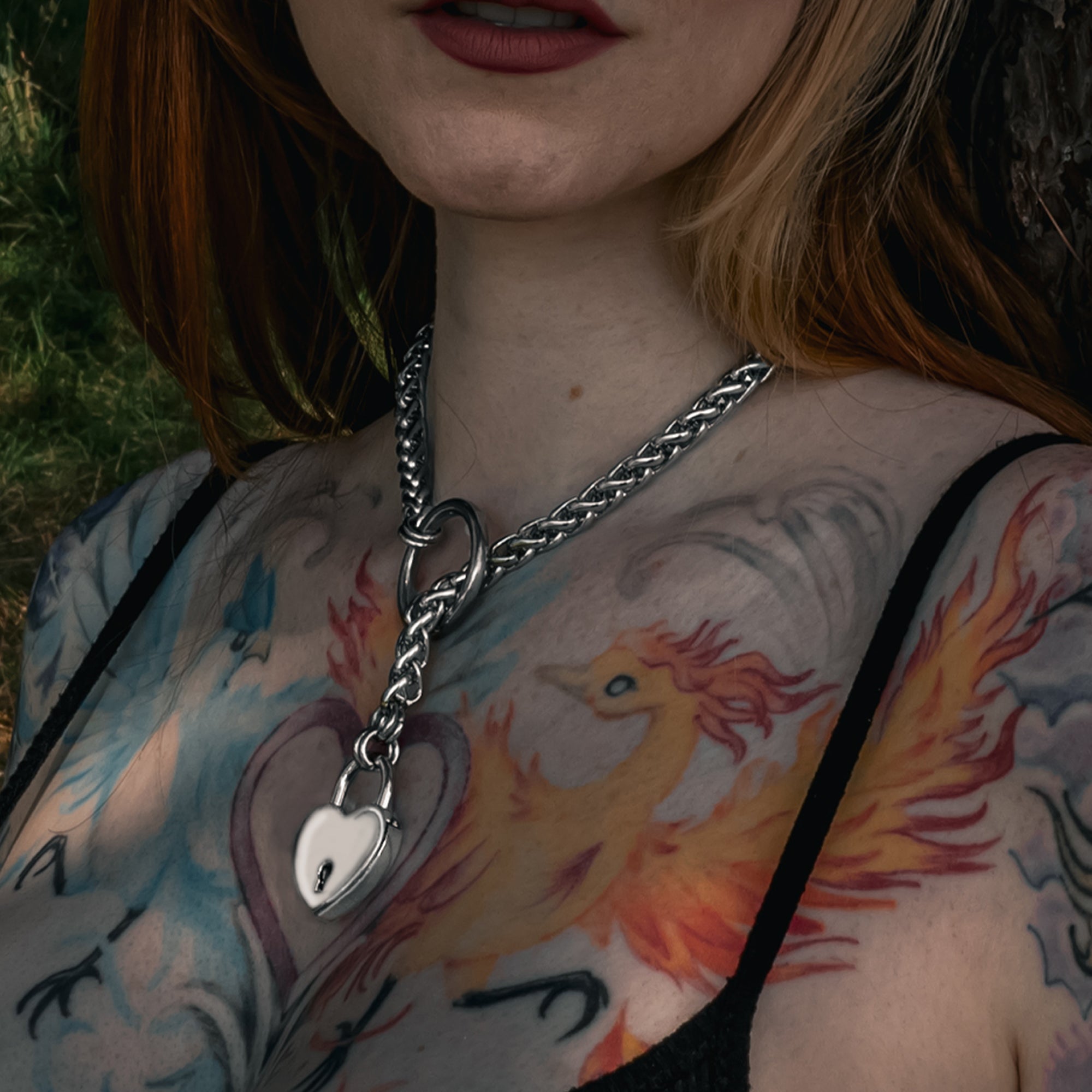 Close up of silver coloured chunky foxtail slip chain choker with heart shaped padlock on a necklace