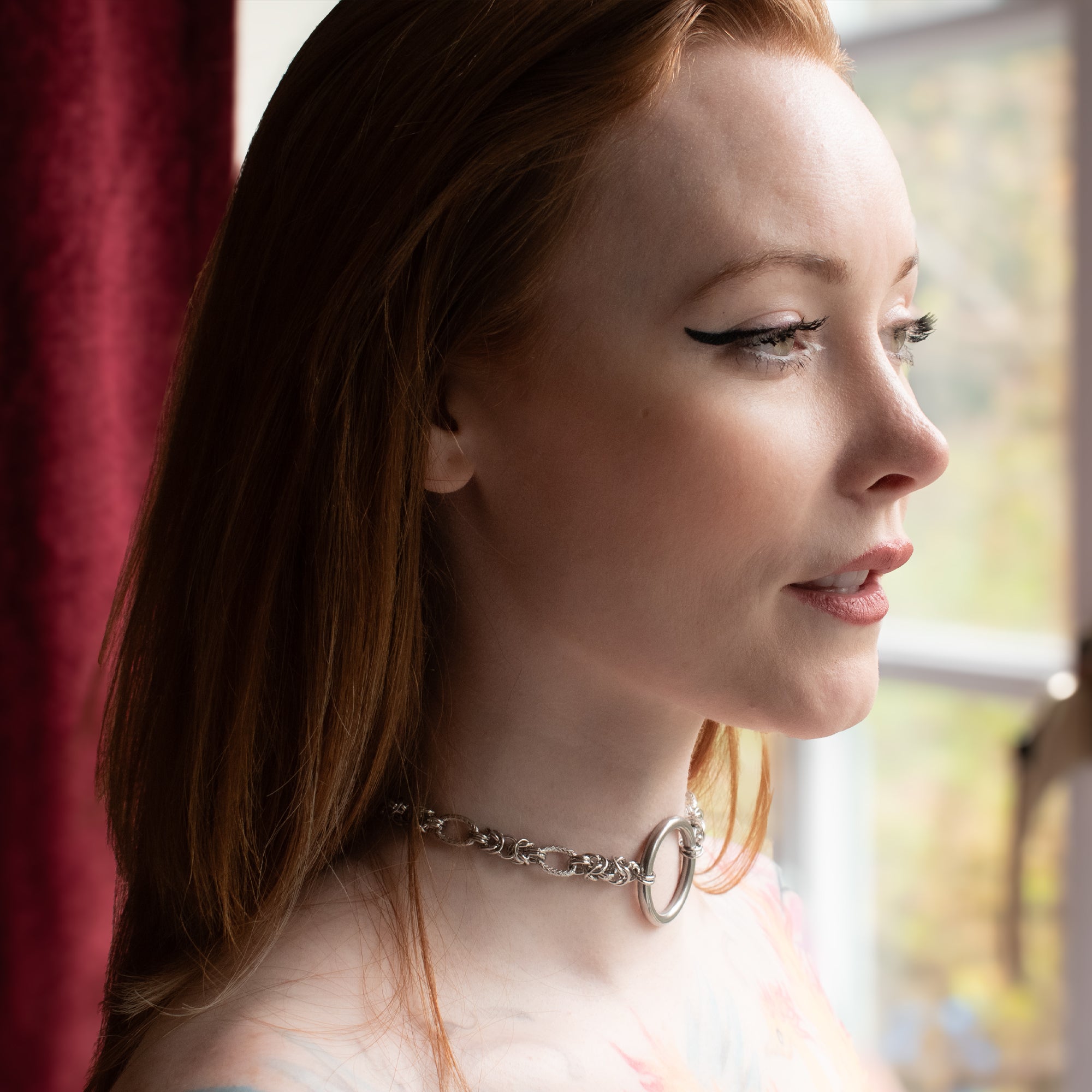 Close up of a silver coloured chunky byzantine chainmail style O ring day collar worn by model