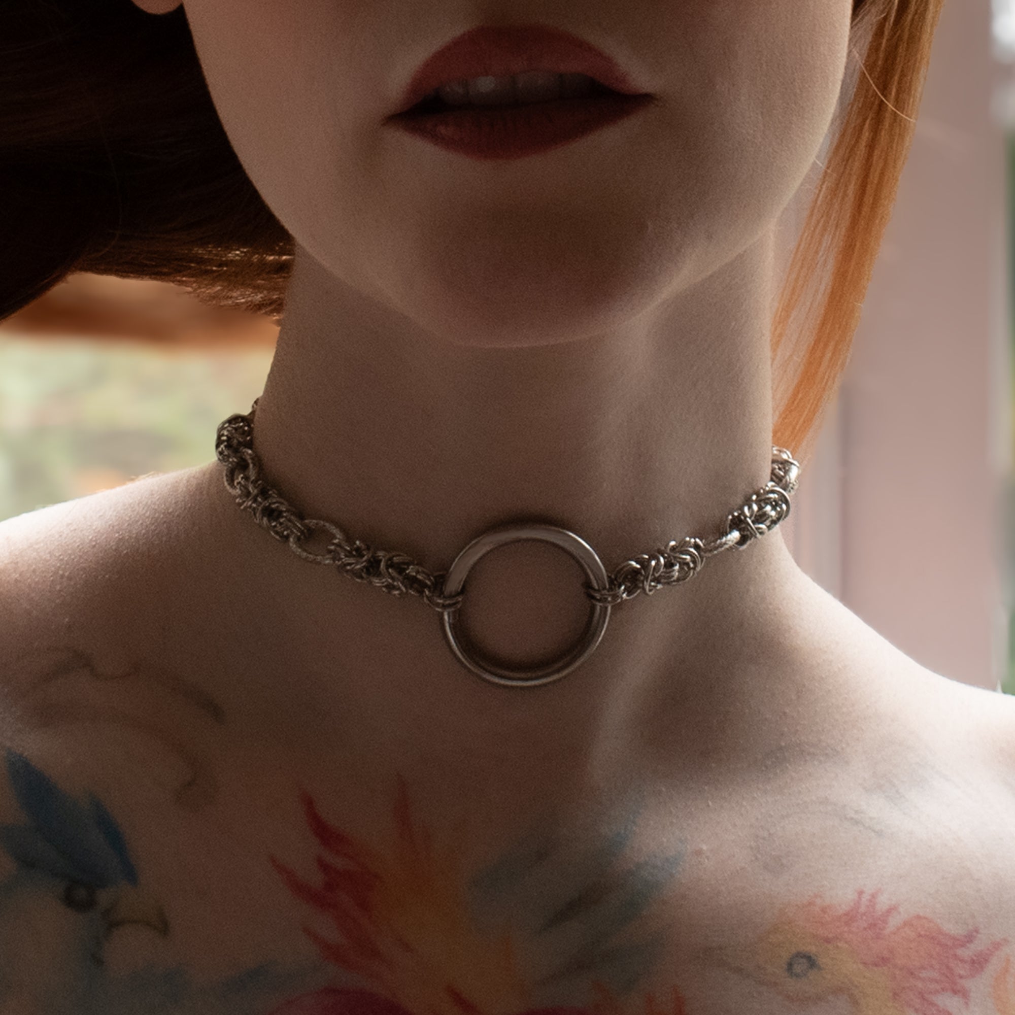 Close up of a silver coloured chunky byzantine chainmail style O ring day collar worn by model