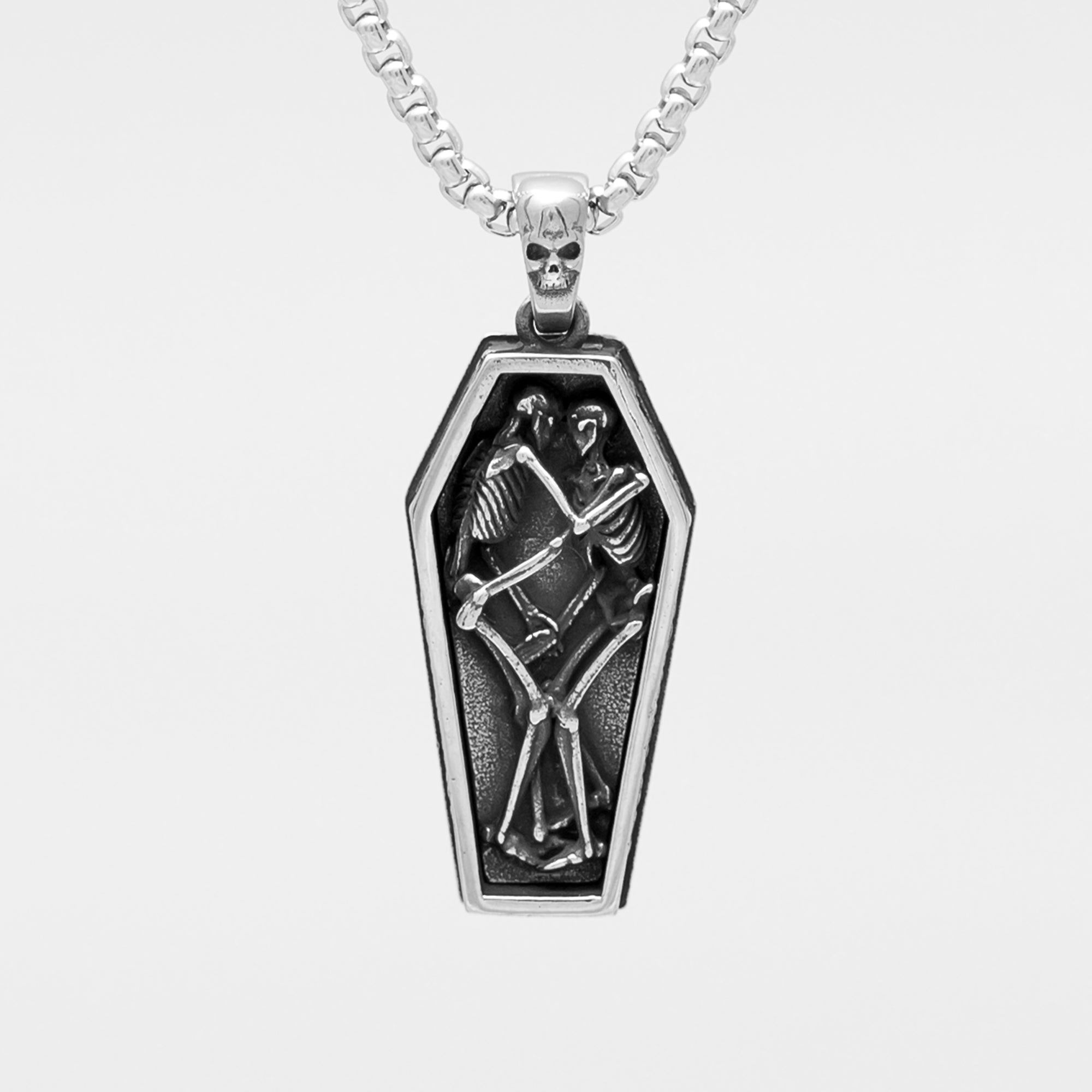 a silver coffin pendant featuring 2 skeletons on a silver box chain 