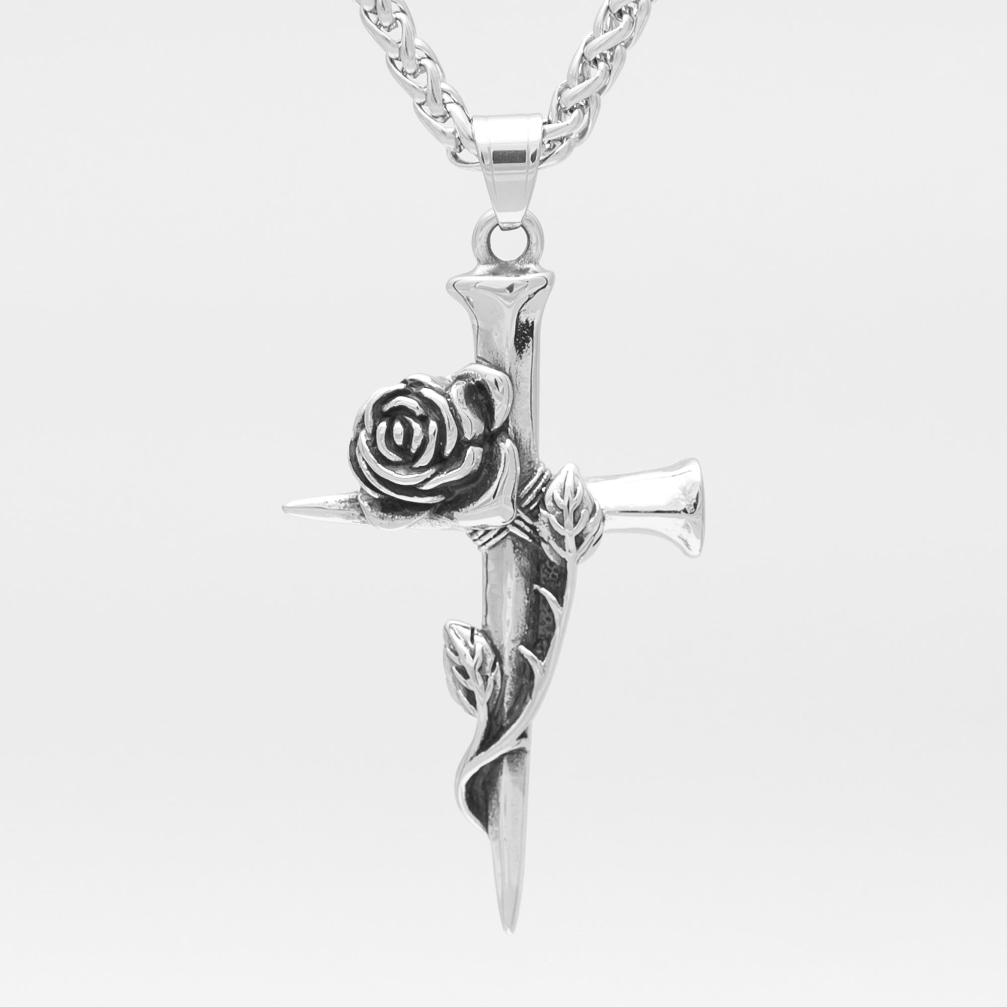 a large silver gothic cross pendant made of wooden stakes featuring an entwined rose 