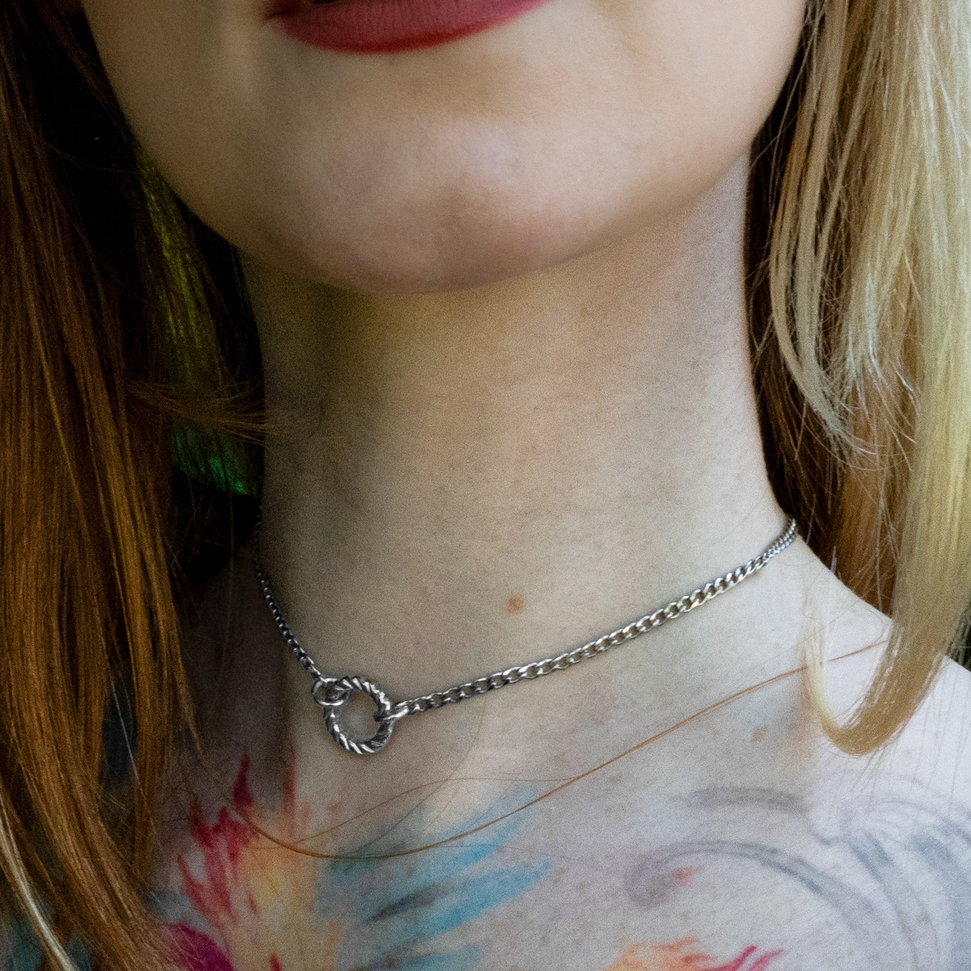 Silver coloured small rope style O ring day collar on a dainty cuban chain