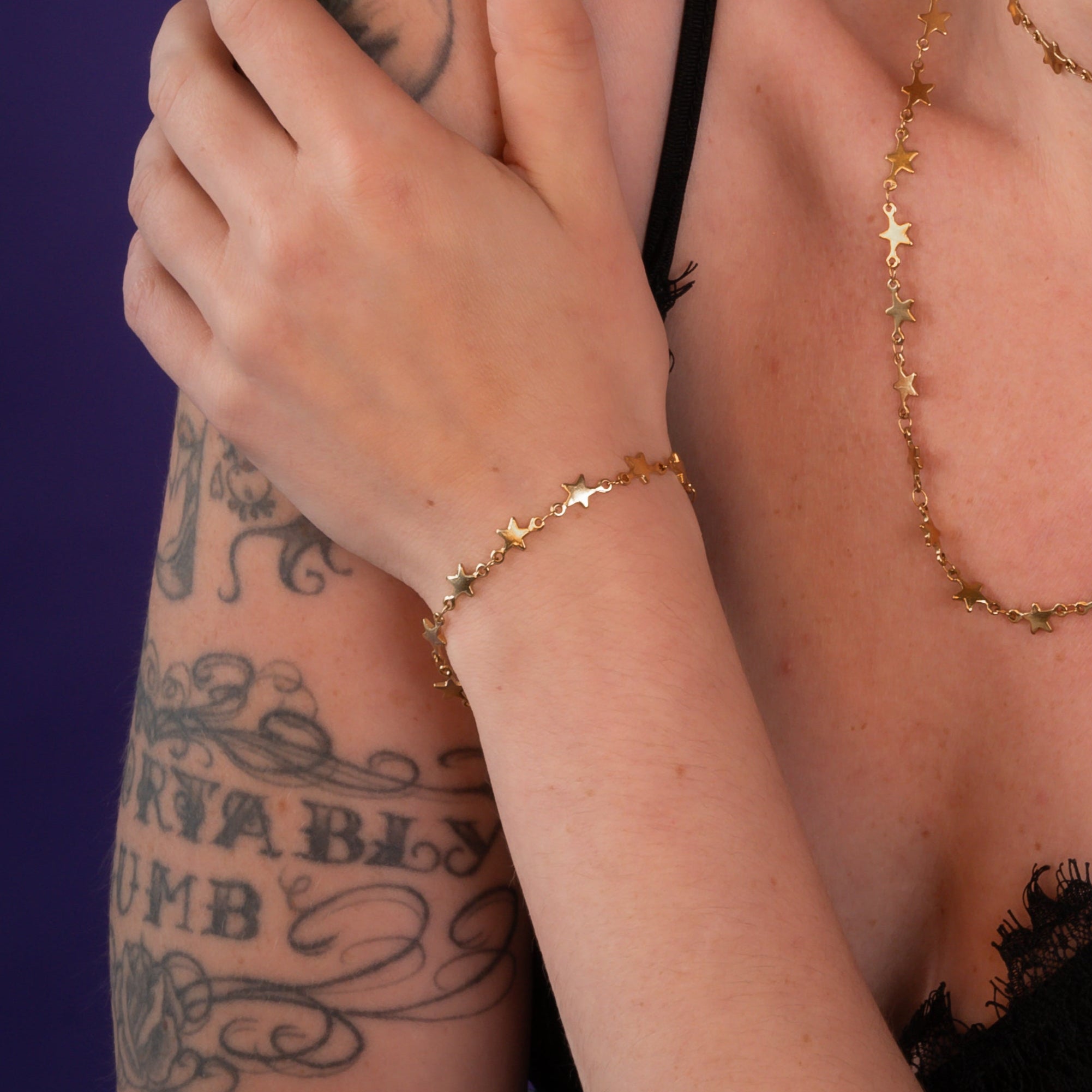 Woman wears Gold star link bracelet with matching choker and necklace 